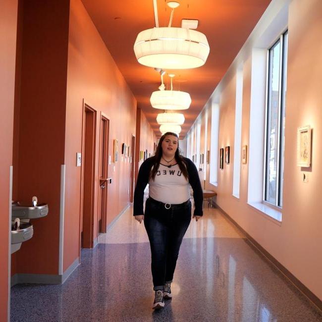 Student walking down the Graham Avenue Walking Gallery at the Pablo Center